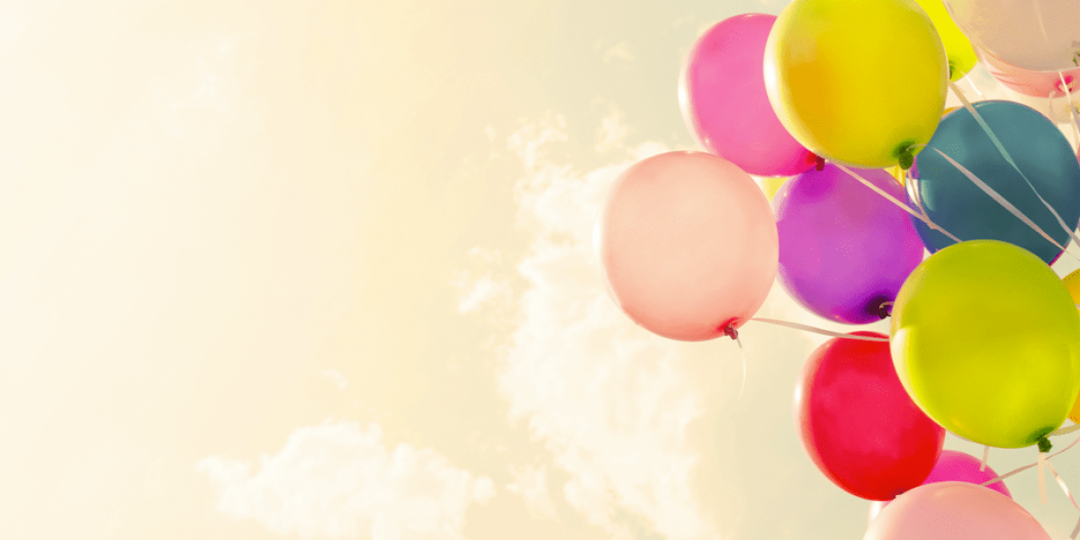 Fotografía de globos de colores volando al viento